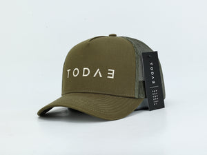 An olive green trucker cap with a curved brim, featuring the brand name 'TODAE' embroidered in white on the front. The back of the cap is made of olive green mesh, and a black hangtag with the brand name is attached.